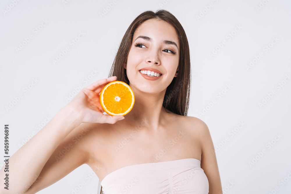 Beauty funny portrait of happy smiling asian woman with dark long hair with oranges in hands on white background isolated Beauty funny portrait of happy smiling asian woman with dark long hair with oranges in hands on white background isolated