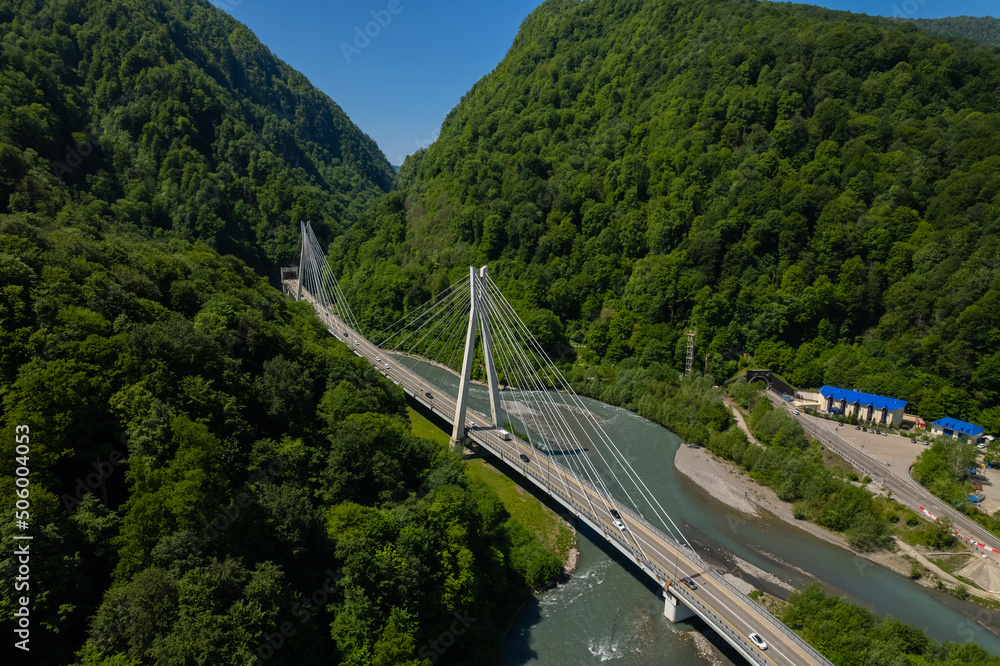 Cable-Stayed Bridge on the Adler-Krasnaya Polyana motorway. Aerial view of car driving along the winding mountain road in Sochi, Russia.