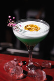 Close-up of an alcoholic cocktail with an orange, decorated with a flower and ice in a nightclub, bar