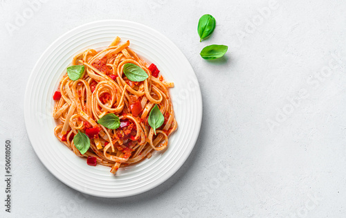 A portion of linguini pasta with tomato sauce and basil on a gray background with a copy space. Traditional Italian pasta.