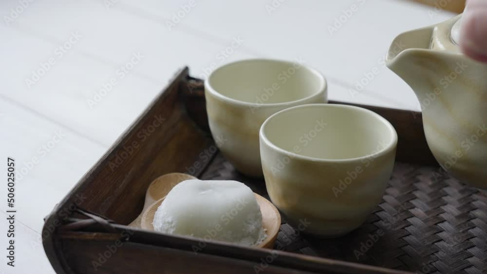 Hot Tea was Poured into Teacup Served with Daifuku on Table in Restaurant Hot Tea was Poured into Teacup Served with Daifuku on Table in Restaurant