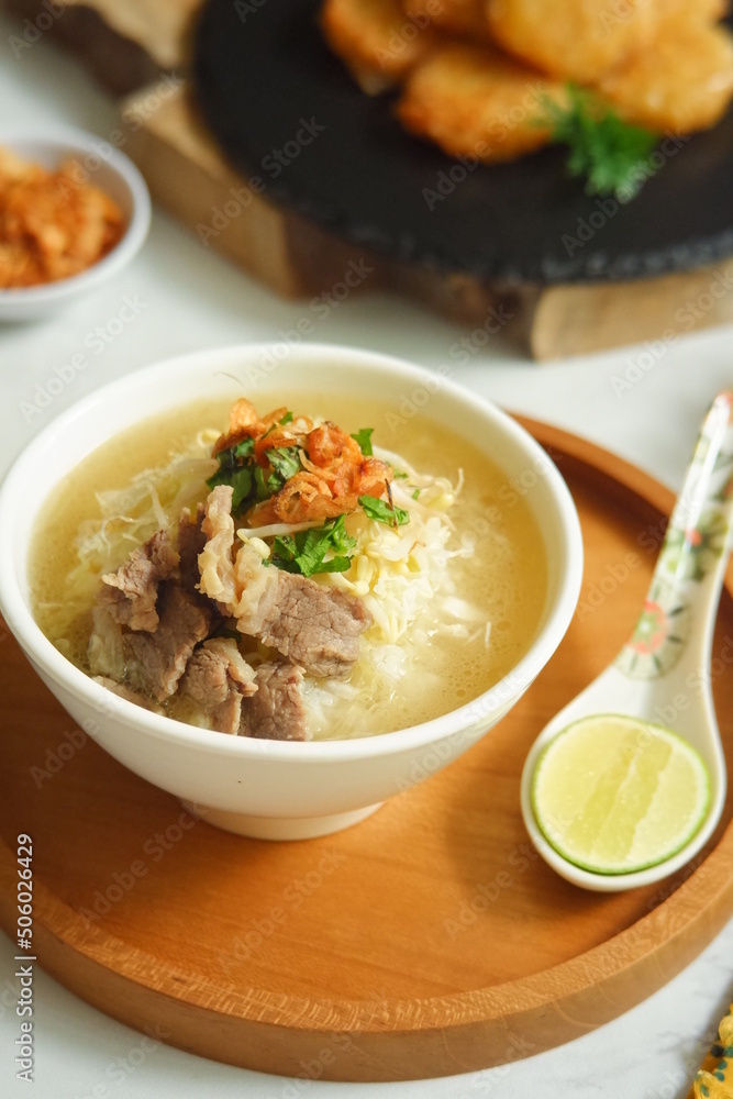 a bowl of beef vegetables clear soup served with rice named soto in Bahasa a bowl of beef vegetables clear soup served with rice named soto in Bahasa