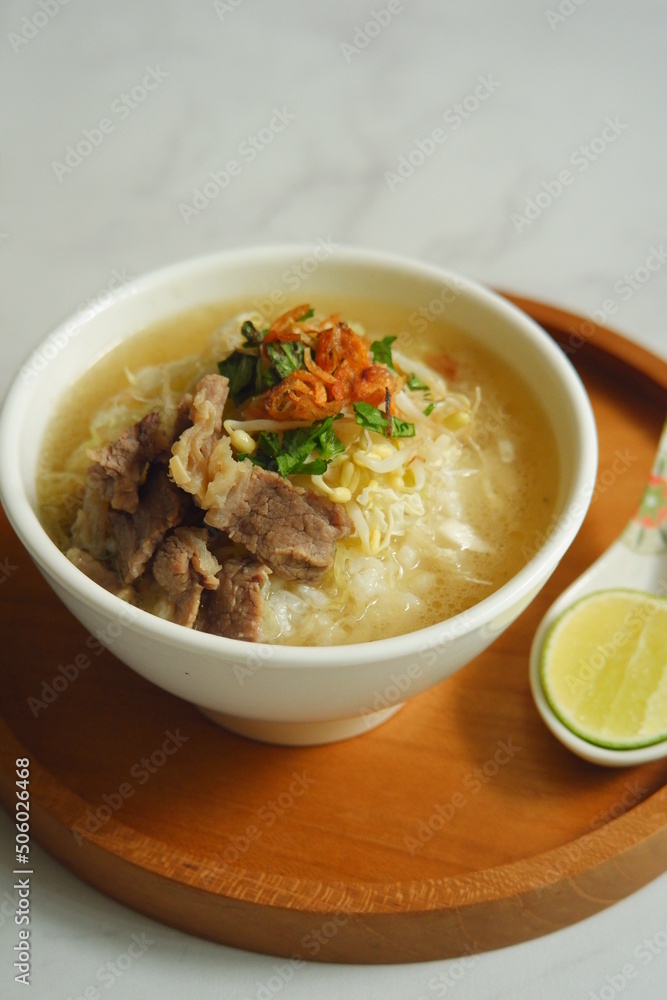 a bowl of beef vegetables clear soup served with rice named soto in Bahasa a bowl of beef vegetables clear soup served with rice named soto in Bahasa