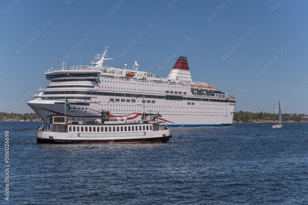 Old ferry meets a cruise ship and a sailing boat leaves for the archipelago a sunny day in Stockholm