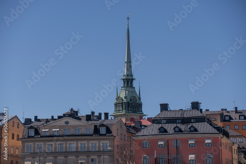 Facades and the spire of the church Tyska Kyrkan in the old town Gamla Stan a sunny day in Stockholm