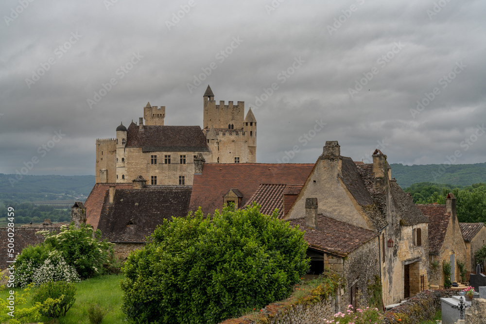 view of the Beynac Castle in the Dordogne Valley under an overcast expressive sky