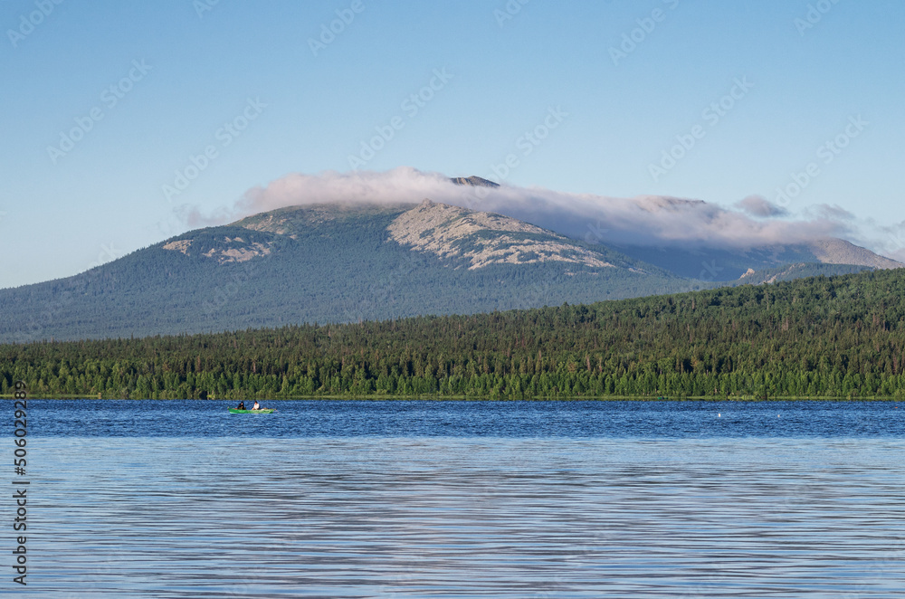 Southern Urals, Ural Mountains. Zyuratkul National Park, Zyuratkul Lake. The boat with fishermen on the background of Mount Lukash.