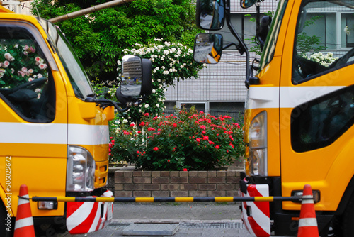 散水車の間から見えるバラ園