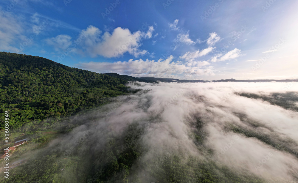 Aerial view Panorama of flowing fog waves on mountain tropical rainforest,Bird eye view image over the clouds Amazing nature background with clouds and mountain peaks in Thailand