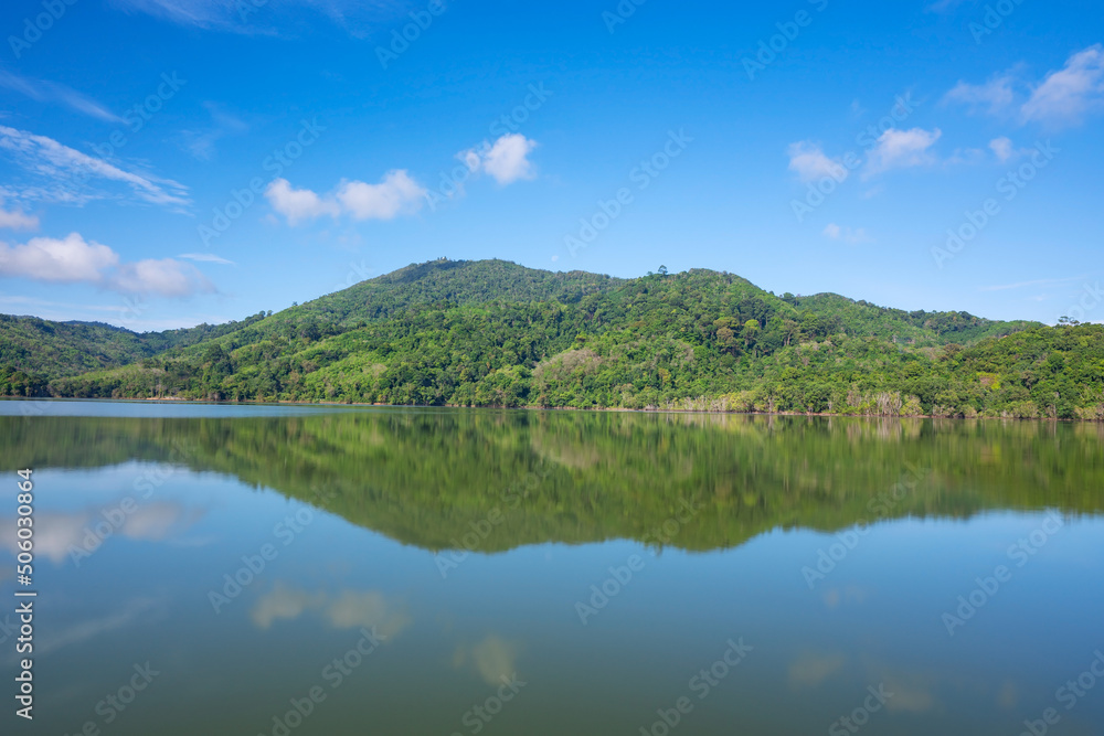 Beautiful reflection of clouds in water surface over lake or pond with Mountain tropical forest landscape nature background