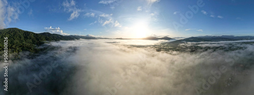 Aerial view Panorama of flowing fog waves on mountain tropical rainforest,Bird eye view image over the clouds Amazing nature background with clouds and mountain peaks in Thailand