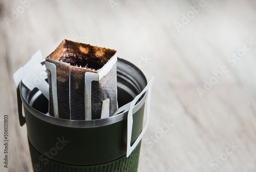 Coffee drip in steel hot coffee cup with copy space, instant hot coffee maker concept
