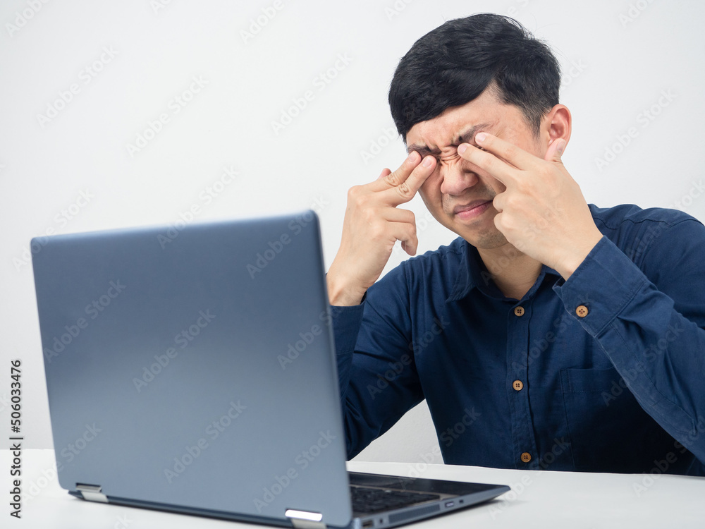 Male employee with laptop tried from working and feel eyestrain,crush eye Male employee with laptop tried from working and feel eyestrain,crush eye