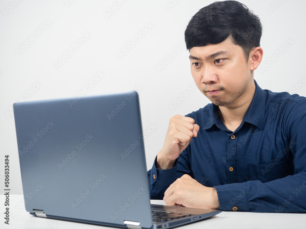 Man gesture confident show fist up looking at laptop on the table Man gesture confident show fist up looking at laptop on the table