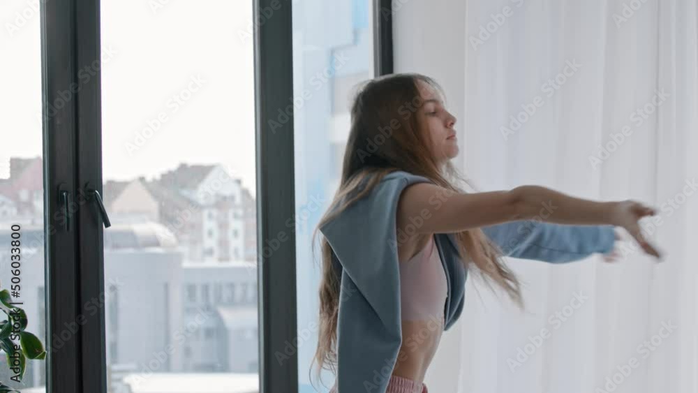 A young woman dances with a half-removed blue sweater A young woman dances with a half-removed blue sweater