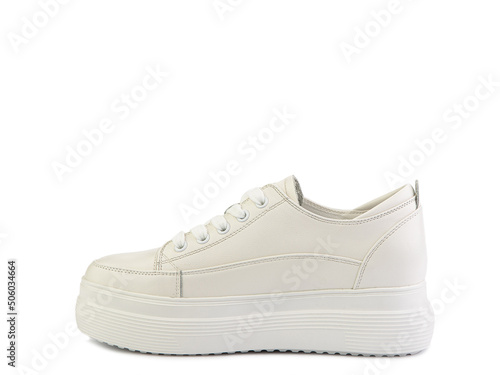 White classic leather trainers. Casual women's style. White lacing and white rubber soles. Isolated close-up on white background.