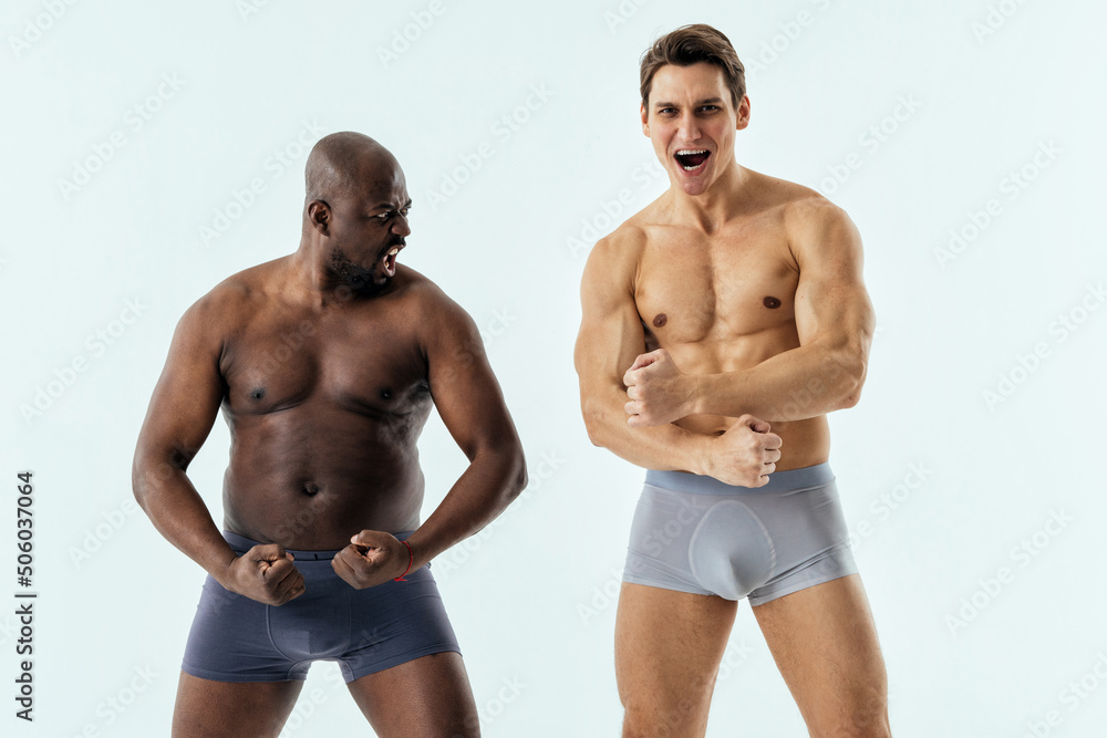 two multiethnic men posing for a male edition body positive beauty set. Shirtless guys with different age, and body wearing boxers underwear two multiethnic men posing for a male edition body positive beauty set. Shirtless guys with different age, and body wearing boxers underwear