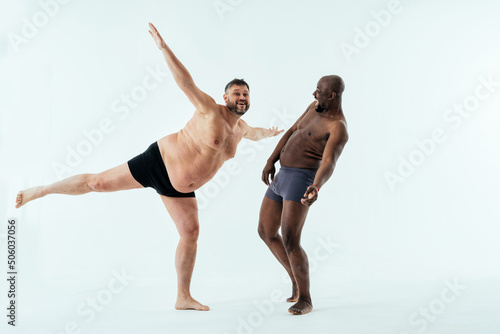 two multiethnic men posing for a male edition body positive beauty set. Shirtless guys with different age, and body wearing boxers underwear