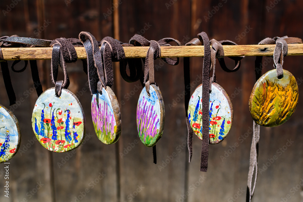Group of colourful hand painted mixed necklaces and suvenirs displayed for sale at a traditional weekend market in Bucharest, Romania.