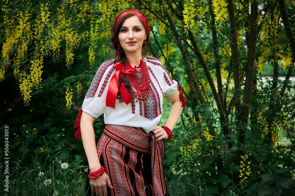 Ukrainian woman in national costume walks in the city park