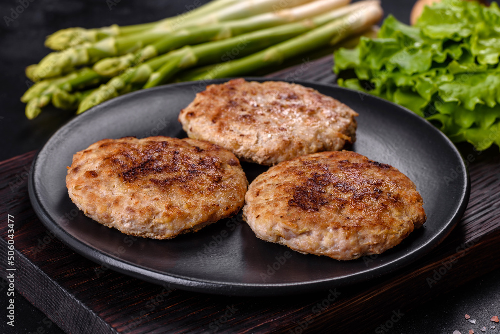 Flat lay composition with grilled meat cutlets for burger on black concrete table Flat lay composition with grilled meat cutlets for burger on black concrete table