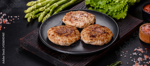 Flat lay composition with grilled meat cutlets for burger on black concrete table