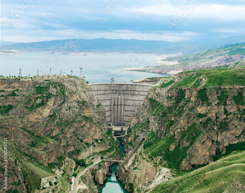 large arch dam of a hydroelectric power station on a river in a mountain gorge photo