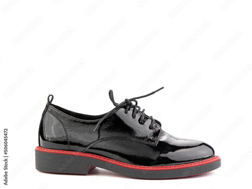 Women's oxford black leather shoes with red stripe isolated white background. Right side view. Fashion shoes. Photoshoot for shoe shop concept.