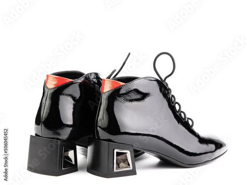 Women's autumn ankle black leather boots with black zip and average heels, isolated white background. Back side view. Fashion shoes.