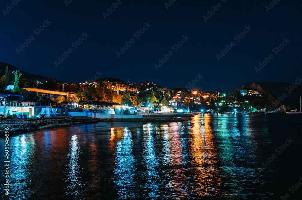 Night landscape of resort village of Gurzuf in Crimea with a view of beach and mountains on Black Sea coast