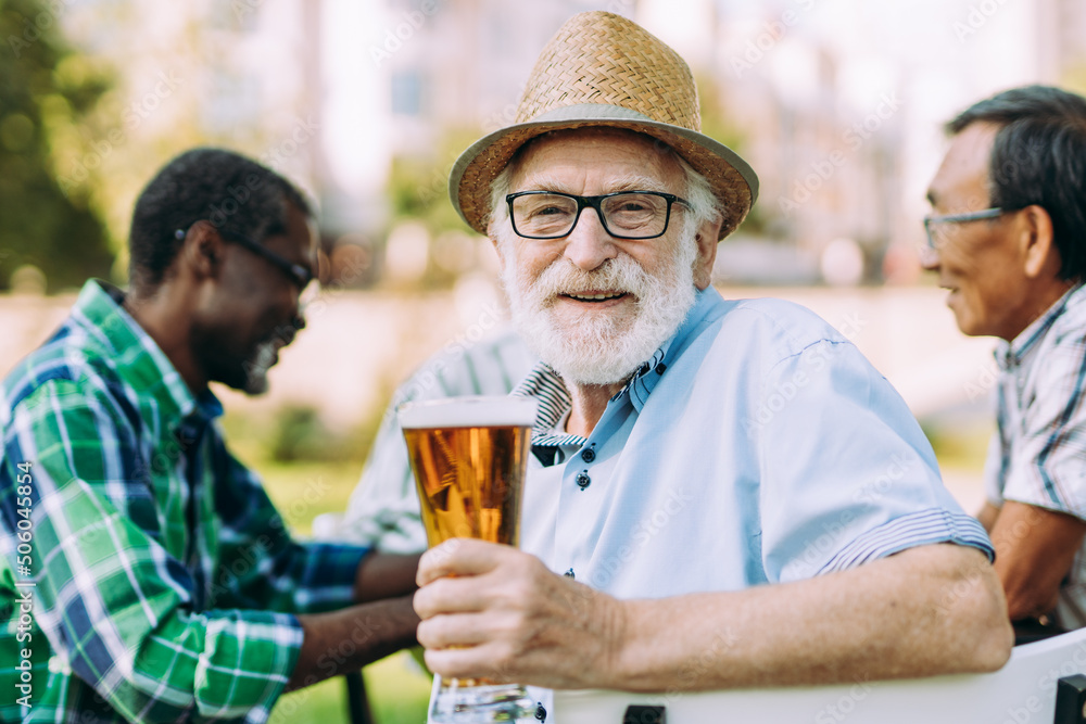 Group of senior friends drinking a beer at the park Group of senior friends drinking a beer at the park