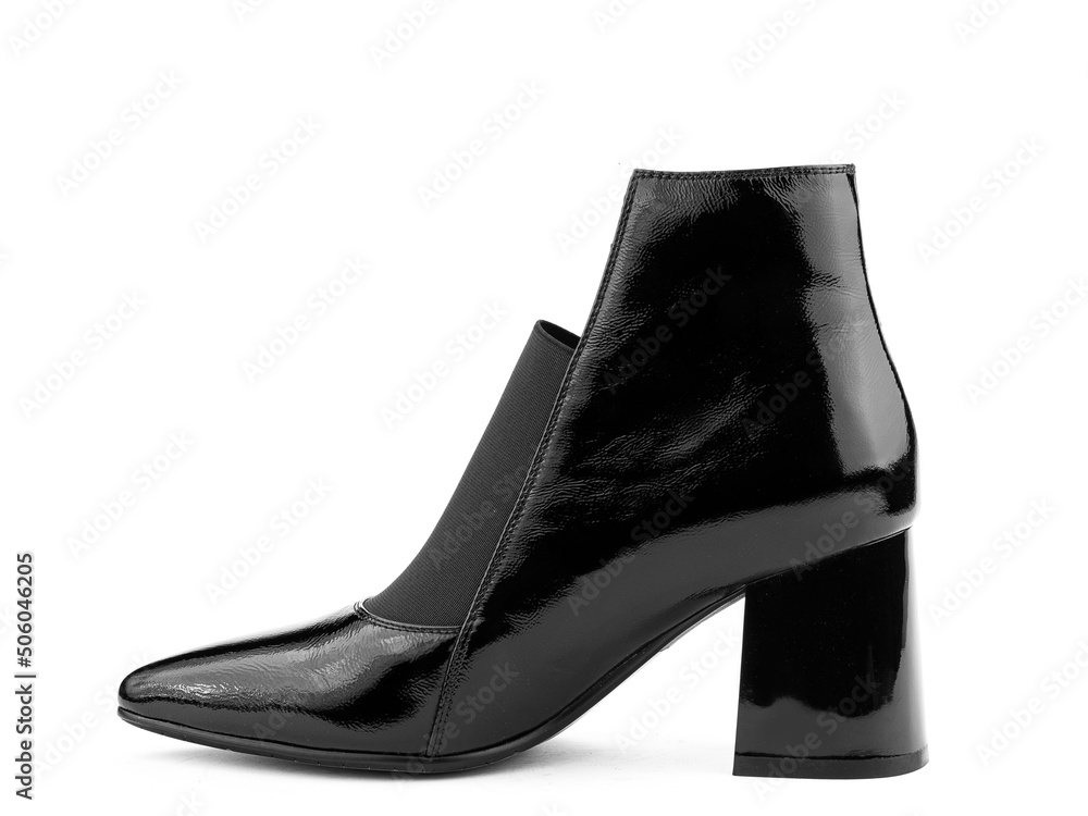 Women's autumn ankle black leather boots with black zip and average heels, isolated white background. Left side view. Fashion shoes.
