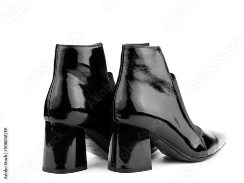 Obraz na płótnie Women's autumn ankle black leather boots with black zip and average heels, isolated white background. Back side view. Fashion shoes. w salonie
