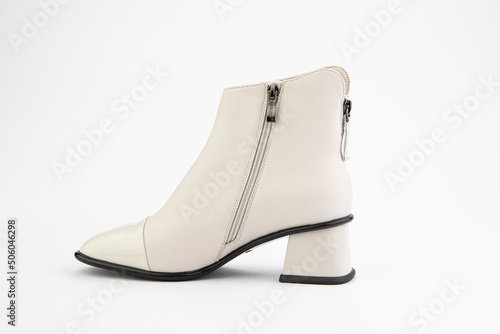 Women's autumn ankle white leather boots with zip and average heels, isolated white background. Left side view. Fashion shoes.