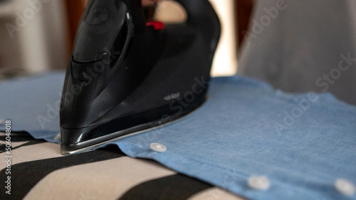Man Ironing clothes with a black iron