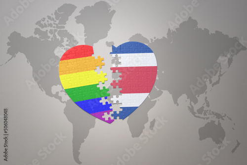 puzzle heart with the rainbow gay flag and costa rica on a world map background. Concept.