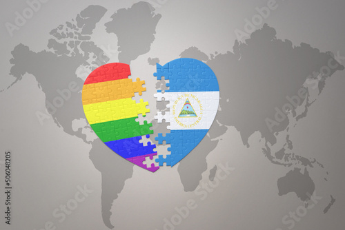 puzzle heart with the rainbow gay flag and nicaragua on a world map background. Concept.