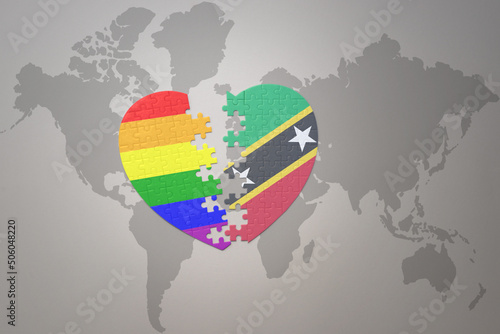 puzzle heart with the rainbow gay flag and saint kitts and nevis on a world map background. Concept.