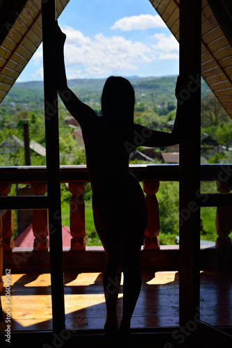 Silhouette of a girl in panties on the balcony