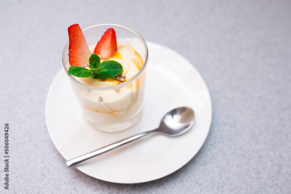 Strawberry parfait with mango sauce decorated with mint leaves Strawberry parfait with mango sauce decorated with mint leaves