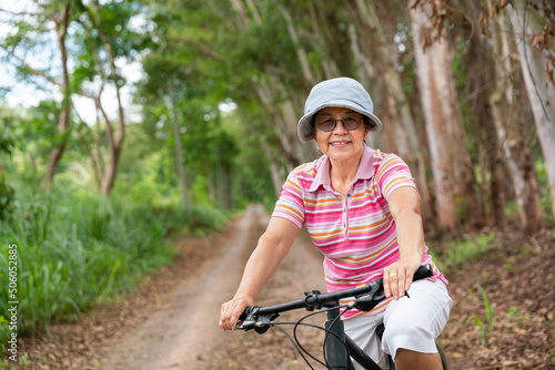 senior business woman, female, ride or bike mountain bicycle in country park near home town for healthy exercise in summer weekend