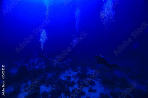 divers underwater at depth in the blue sea background © kichigin19