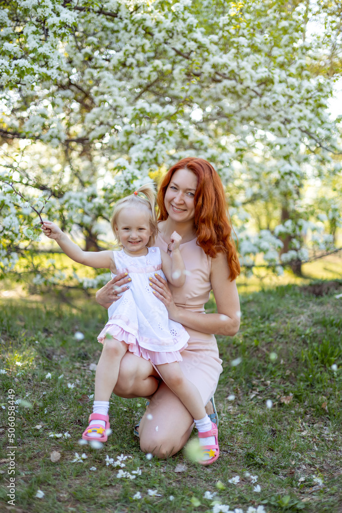 mother and daughter in a flowering garden. mother and daughter in a flowering garden.