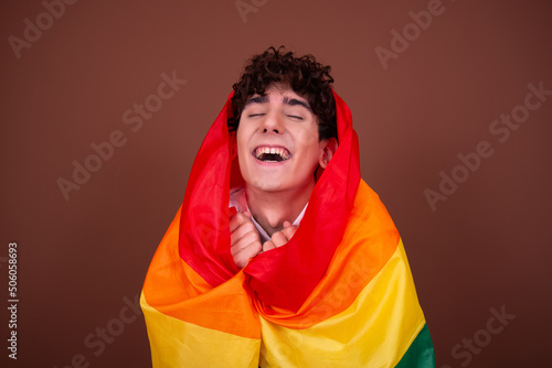 Young attractive guy with a rainbow flag. © vladorlov