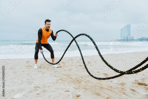 Photography Young handsome man making workout and fitness on the beach in the morning