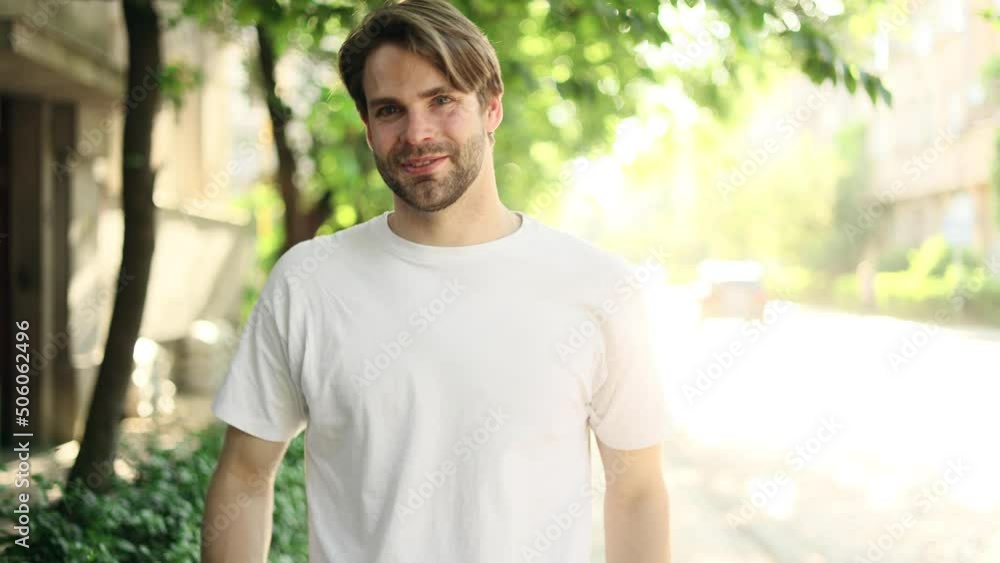 Portrait of a attractive blond man smiling and walking down in the park. Handsome man looking at camera outside. Portrait of a attractive blond man smiling and walking down in the park. Handsome man looking at camera outside.