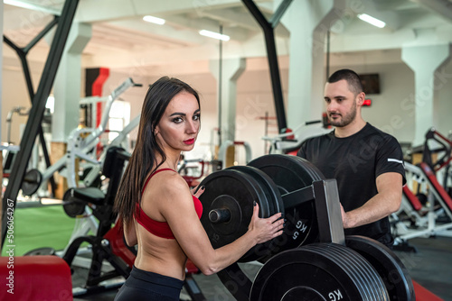 man and woman athletes promising coaches are engaged in two in the gym so as not to lose shape