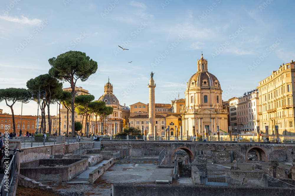Scenic view on ruins of Roman Forum with Churches on skyline. Rome cityscape on sunset. Concept of historical landmarks and travel Italy