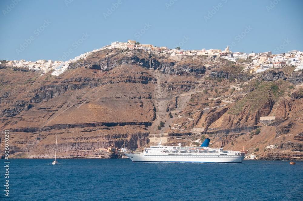 Panoramic aerial view of the village on the caldera, and a cruise ship on the island of Santorini, Greece