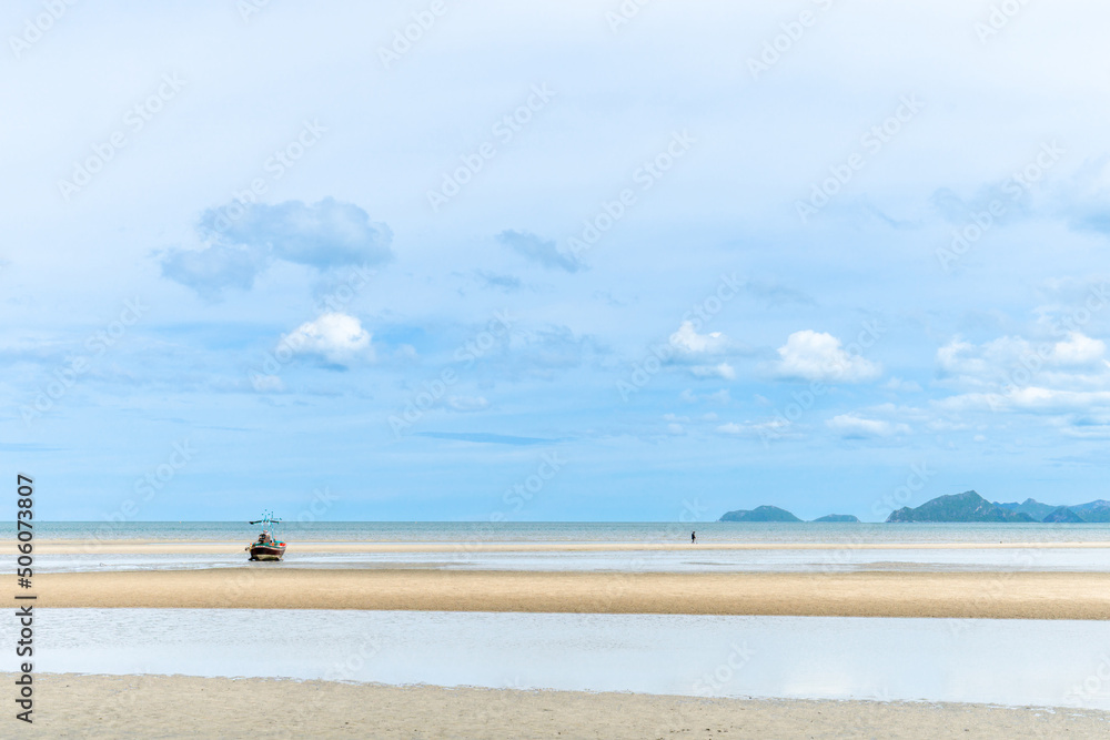 Fishing boats moored on a sandy beach at low tide. and the view of the sky near the rain beautiful natural scenery Khao Kalok Beach, Pranburi, Prachuap Khiri Khan Province Landmark of Thailand Fishing boats moored on a sandy beach at low tide. and the view of the sky near the rain beautiful natural scenery Khao Kalok Beach, Pranburi, Prachuap Khiri Khan Province Landmark of Thailand